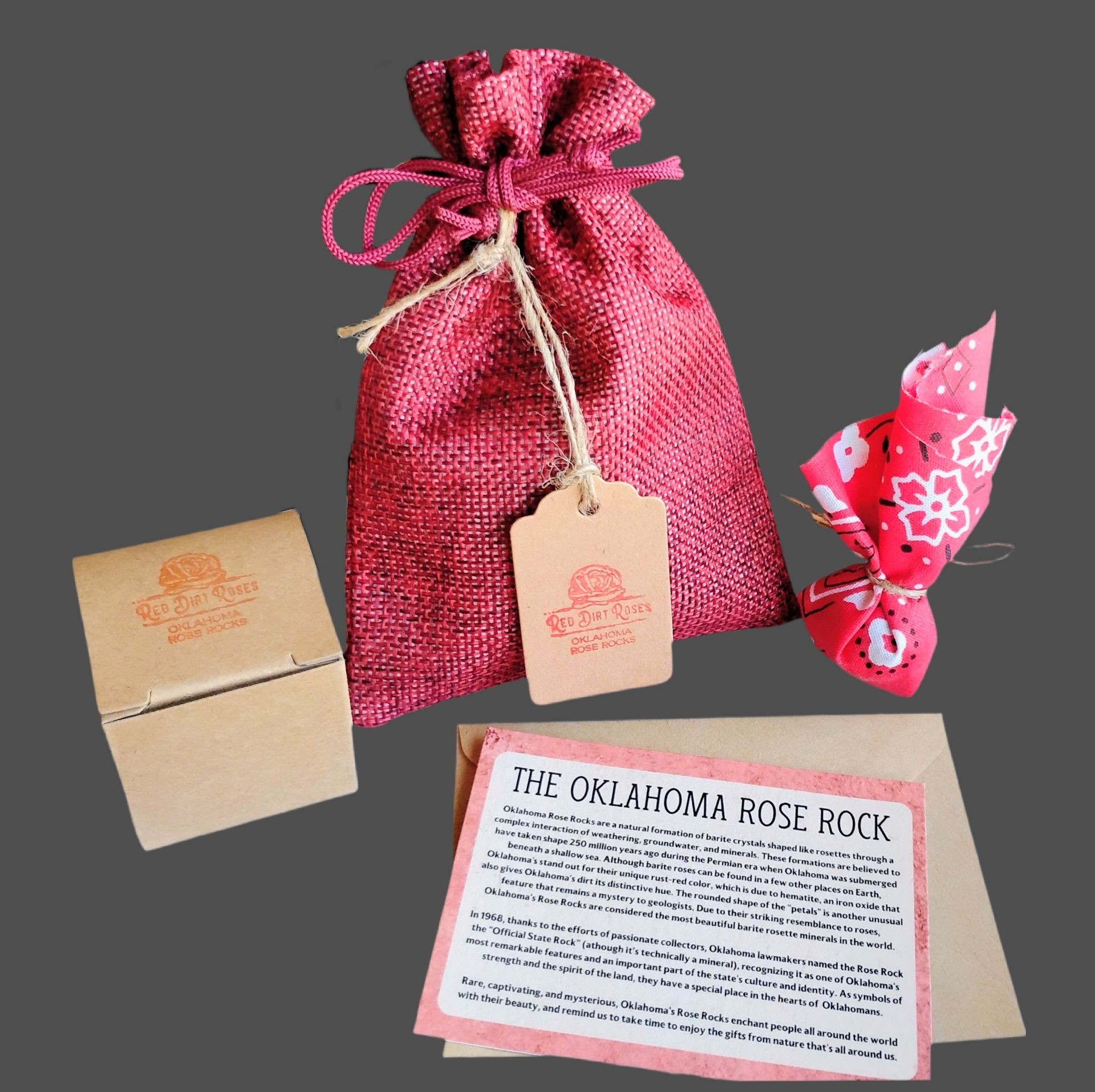 A small box, red bag, and fabric wrapped package displaying the Red Dirt Roses logo on a grey background